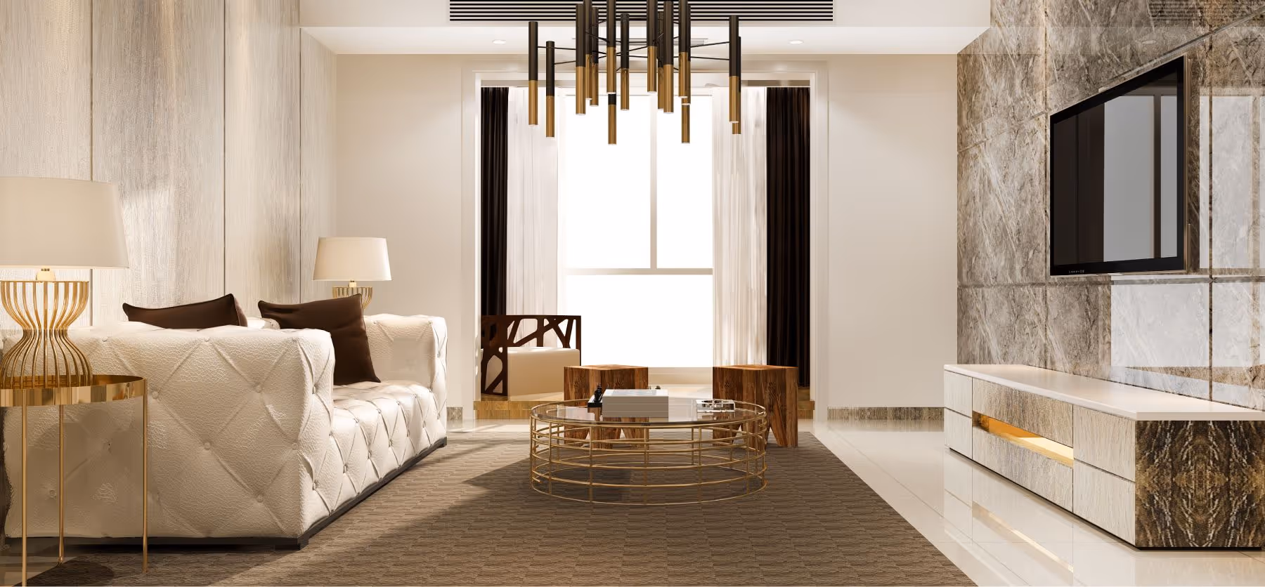 Sala de estar moderna com sofá branco, mesa de centro redonda dourada, duas banquetas de madeira e TV de tela plana na parede de pedra.