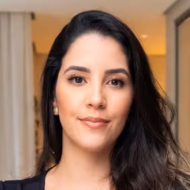 Rosto de mulher jovem com cabelo preto, pele clara e expressão serena em ambiente interno com iluminação suave.